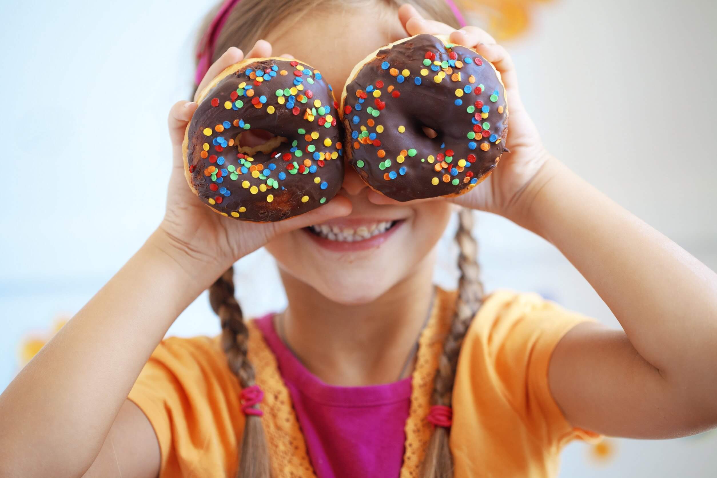Сладость малышам. Пончики для детей. Девушка с пончиком. Фотосессия со сладостями. Сладости для детей.