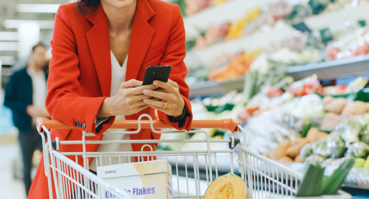 Frau mit Smartphone beim Einkaufen