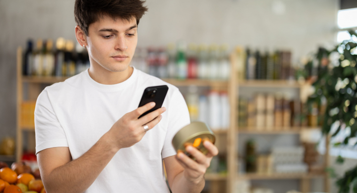 Mann mit Smartphone betrachtet ein Produkt Mann mit Smartphone betrachtet ein Produkt