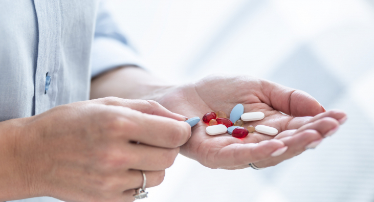 Person hält verschiedene Kapseln und Tabletten in der Hand Person hält verschiedene Kapseln und Tabletten in der Hand