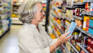 Ältere Frau liest Packungstext
