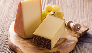 Holzbrett mit Stücken von Hartkäse Holzbrett mit Stücken von Hartkäse