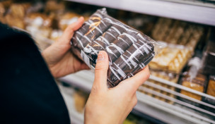 Frau hält Packung mit Gebäck Frau hält Packung mit Gebäck