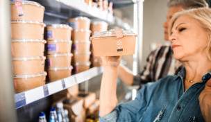 Frau schaut Salatverpackung an, prüft Kennzeichnung