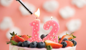 rosa-kerze-auf-kuchen-mit-beeren-und-feuerzeug