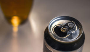 Bierdose mit Bier im Hintergrund