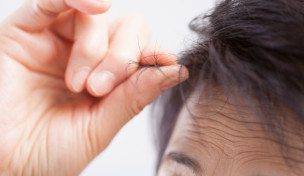 Frau fasst sich ins Haar