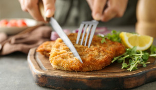 Schnitzel wird mit Besteck angeschnitten