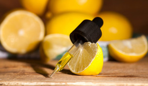 Pipette mit Öl vor aufgeschnittenen Zitronen