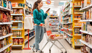 Frau mit Smartphone im Supermarkt