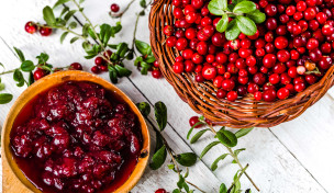 Preiselbeerenmarmelade neben frischen Preiselbeeren auf einem Tisch