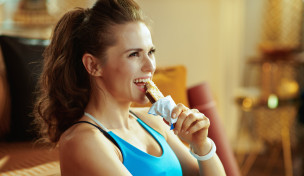 Sportlerin isst Proteinriegel