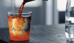 Sirup wird in ein Wasserglas gegeben
