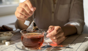 Mann nimmt einen Teebeutel aus der Tasse