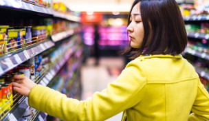 Frau vor dem Supermarktregal