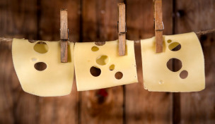 Emmentaler Käse hängt an einer Wäscheleine