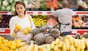 Verbraucherin begutachtet Obst