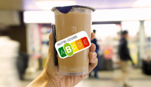 Hand hält Kaltgetränk im Supermarkt