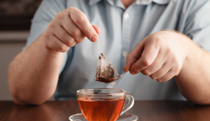 Teebeutel und Teetasse mit Person