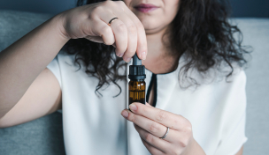 Frau, die cbd-Tropfen hält