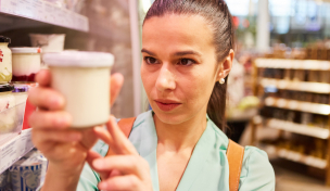 Frau prüft Joghurtverpackung