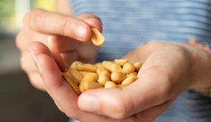 Person snackt Erdnüsse