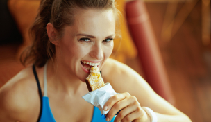 Sportlerin isst Proteinriegel