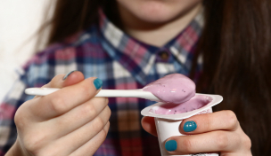 Person isst Fruchtjoghurt