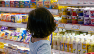 Kind vor dem Kühlregal im Supermarkt Kind vor dem Kühlregal im Supermarkt