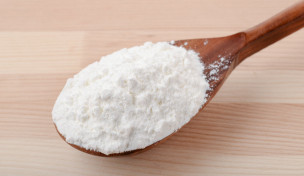 Löffel Maisstärke auf Holzuntergrund