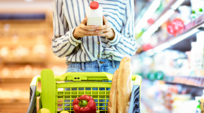 Frau liest auf Milchpackung