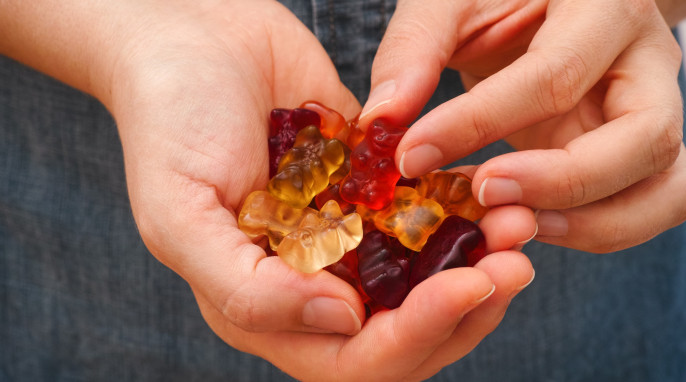 Frau mit Gummibärchen in den Händen