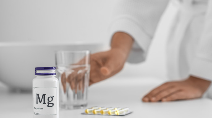Magnesiumtabletten neben einem Glas Wasser auf einem Tisch