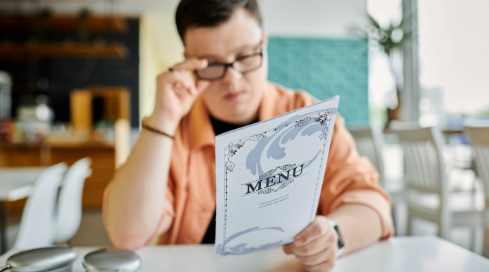 Mann liest Speisekarte in einem Restaurant