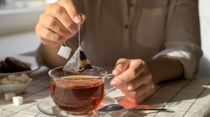 Mann nimmt einen Teebeutel aus der Tasse
