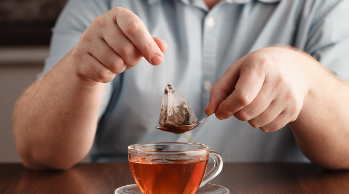 Teebeutel und Teetasse mit Person