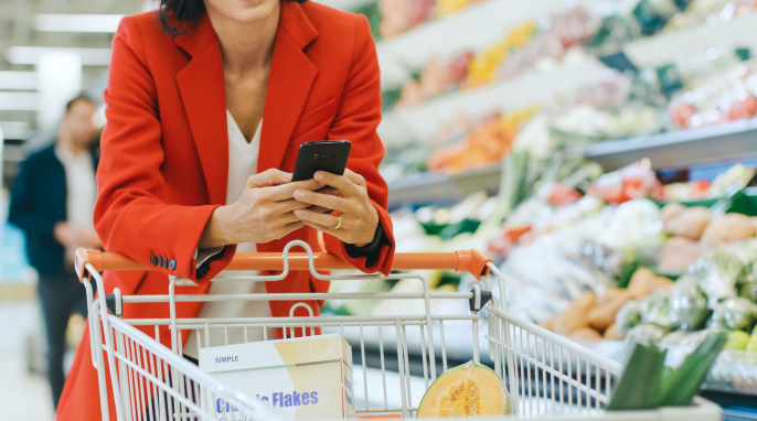 Frau mit Smartphone beim Einkaufen