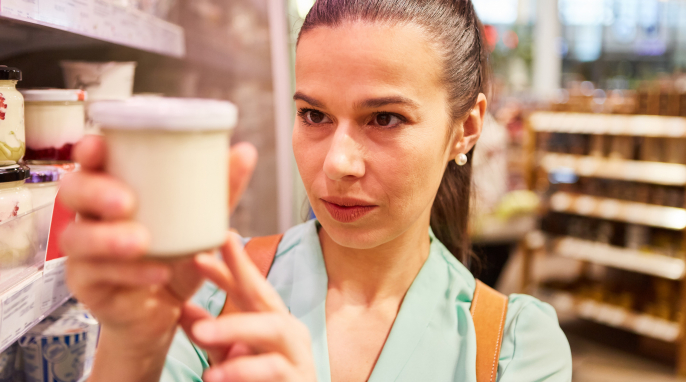 Frau prüft Joghurtverpackung