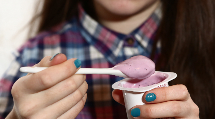 Person isst Fruchtjoghurt