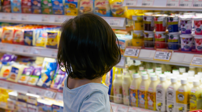 Kind vor dem Kühlregal im Supermarkt Kind vor dem Kühlregal im Supermarkt