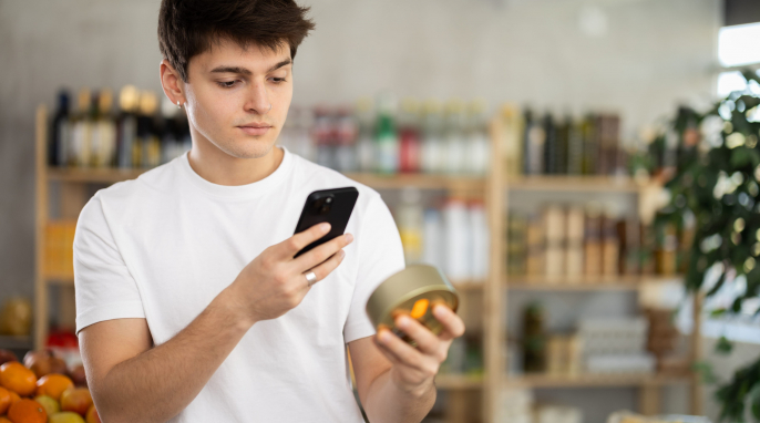 Mann mit Smartphone betrachtet ein Produkt