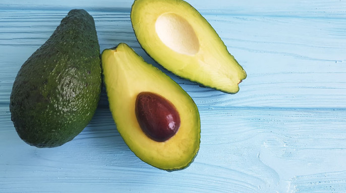 Frische Avocado auf blauem hölzernem Untergrund