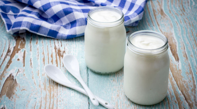 Zwei Gläser Joghurt auf Holzbrett