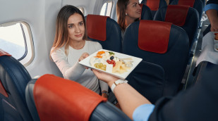 Junge Frau erhält im Flugzeug ihre Mahlzeit