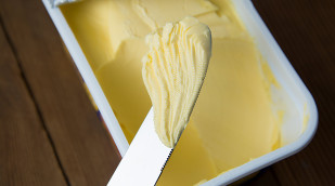 Margarine in einem Becher und ein Messer