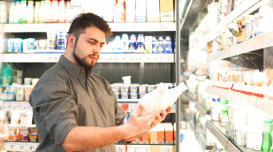 Mann studiert das Etikett von Milchprodukten