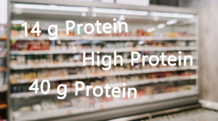 Supermarktregal mit Milchprodukten, darüber verschiedene Proteinangaben