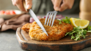 Schnitzel wird mit Besteck angeschnitten