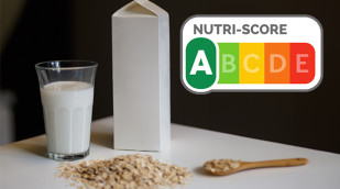 Glas und Tetrapack mit Hafermilch auf einem Tisch. Nutri Score mit Kateogorie A.