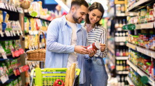 Paar im Supermarkt schaut sich die Rückseite eines Lebensmittels an